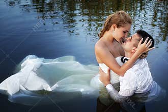 Love and passion - kiss of married couple in water