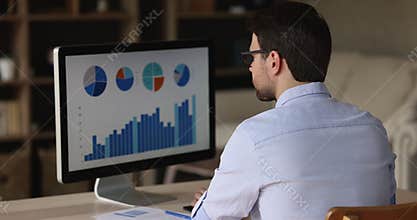 Businessman sit at desk analyze charts and graphs on pc
