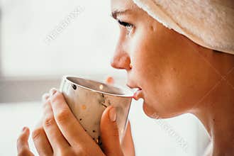 Young serene relaxed woman in spa bath towel drinking hot beverage tea coffee after taking shower bath at home. Beauty