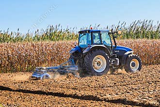 man driving tractor plowing land