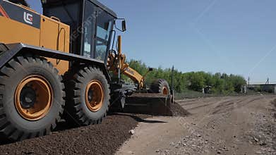 Leveling the ground with a grader blade