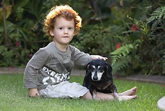 Toddler and dog sitting in garden