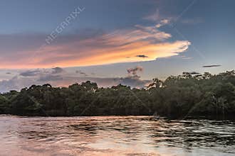 Reflection of a sunset by a lagoon inside the Amazon Rainforest Basin.