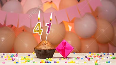Decorations with balloons and a happy birthday candle with the number 41 for a woman. Happy birthday greetings in pink flowers