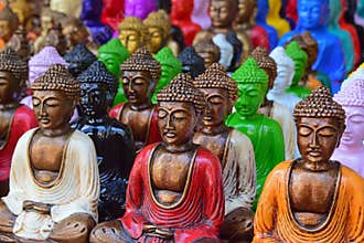 Bold, colourful rows of Buddhist Buddha statues in different bright striking strong attractive colour on display