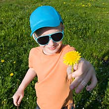 Boy giving dandelion to mom