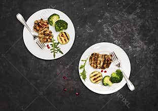 Turkey or chicken cutlets meatballs zucchini and broccoli in white plates on black background  top view. Healthy balanced food