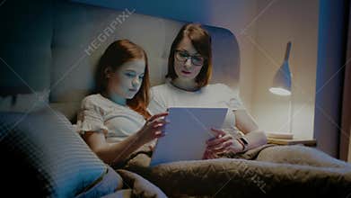 Daughter and mom watch movie on tablet