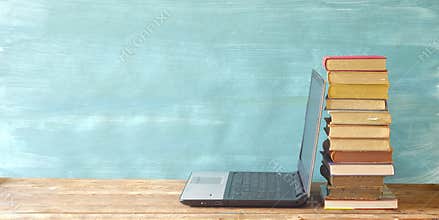 Stack of books and laptop computer,e-book reader. E- Book,E-Learning,online education, home office concept. copy space