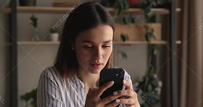 Smiling beautiful young woman using mobile application.