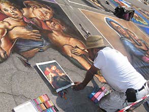 pavement street artist painting over the asphalt in Madonnari competition of chalk paintings