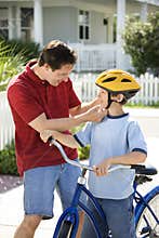 Dad helping son with helmet