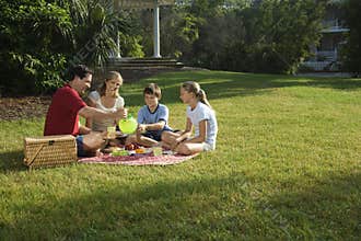 Family having picnic in park.