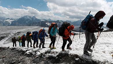 A team of climbers ascending an icy slope on Mt. Everest across the sky above. Clip. People enjoying climbing a snowy