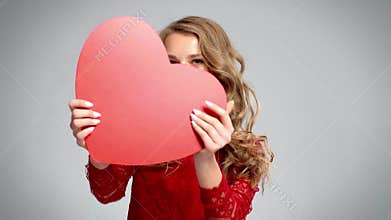 Playful woman showing valentine card