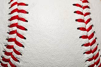 A macro of a baseball with red stitching and room for copy on the ball