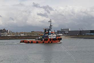 Powerful red color tugboat getting back to the harbor