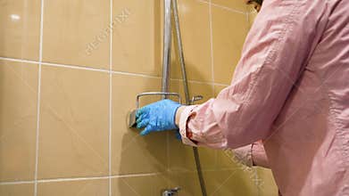 Housemaid rubbing soap dish with brush during cleanup