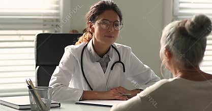 Professional young female general practitioner consulting old woman.