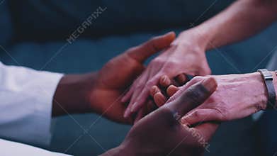 Close up, african american black doctor holding hand of elderly caucasian woman
