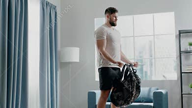 Bodybuilder guy practices biceps curl with weight in bag
