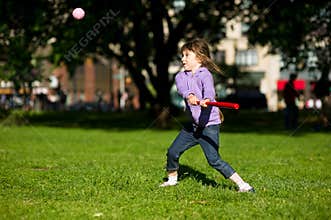 Child girl playing baseball in park