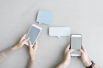 Hands holding mobile phones featuring speech bubbles