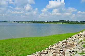 Green pasture and stones by a reservoir