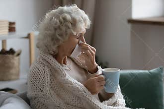 Sick elderly 60s lady suffering from cold or flu