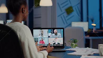 Back view of black business woman talking on video call with team