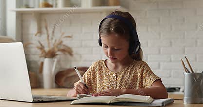 Little girl do assignment, talks to teacher by video call