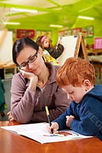 Kindergarten preschool teacher helping children