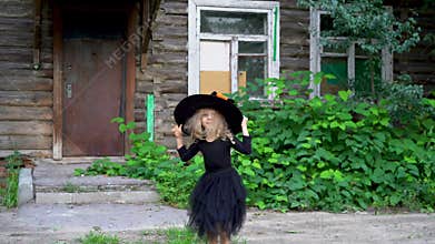 a little girl in a masquerade costume for Halloween dancing and spinning