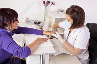 Nail designer giving skin care