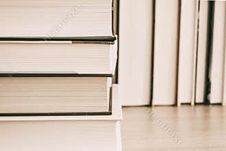 Hardback books on wooden shelf on the deck table, no labels, blank spine. Back to school. Education background