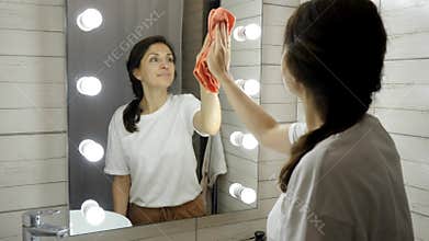 Portrait of young happy woman is cleaning house with smile