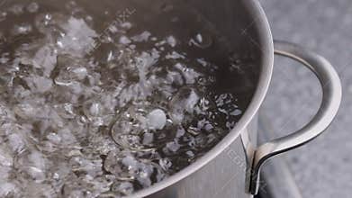 Close up of bubbles in boiling water. Fragment of