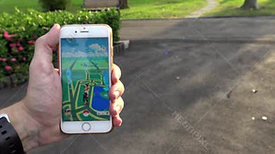 4K Man playing Pokemon Go on App in Monument of Asia Park, used smart phone