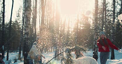 WINTER FUN. Idyllic cinematic shot, happy diverse friends enjoying snowball fight at snowy forest with dog slow motion.