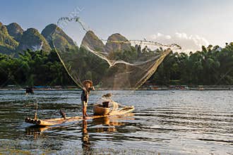 Fishermen casting nets in the sunset