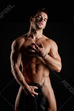 Muscular young naked man wrapped in silk