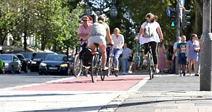 People walk cross the road, and cyclist ride bicycle on bicycle lane at pedestrian crossing.