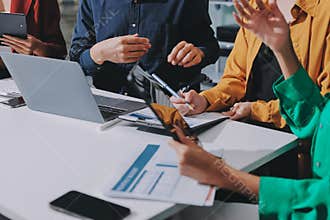 Young corporate employees sitting in office looking at laptop screen reading good news excited happy team diverse people