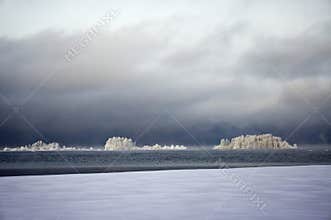 White forest islands on the black Ladoga Lake