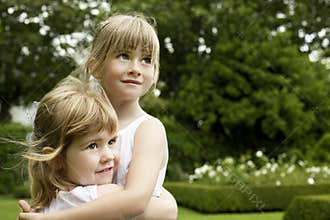 Girls Embracing In Garden