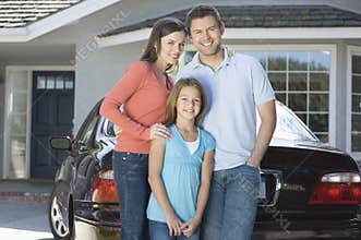 Portrait Of Happy Family Against Car And House