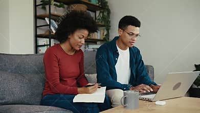 two African American university students working on an assignment together on a laptop