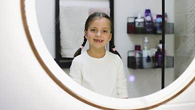 Adorable young girl with missing teeth in bathroom portrait
