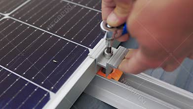 Close up of worker installing and working on maintenance of photovoltaic panel system installed. Mounting solar panel