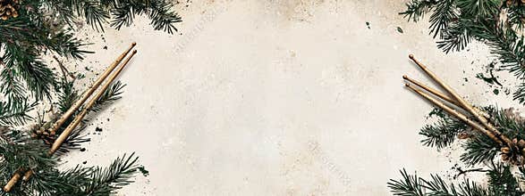 Drumsticks and pine branches border on beige grunge background